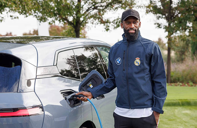 Real Madrid's German defender Antonio Rudiger charges his new electric vehicle 