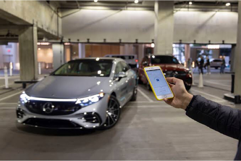 An image showing a man using a phone to control his vehicle.